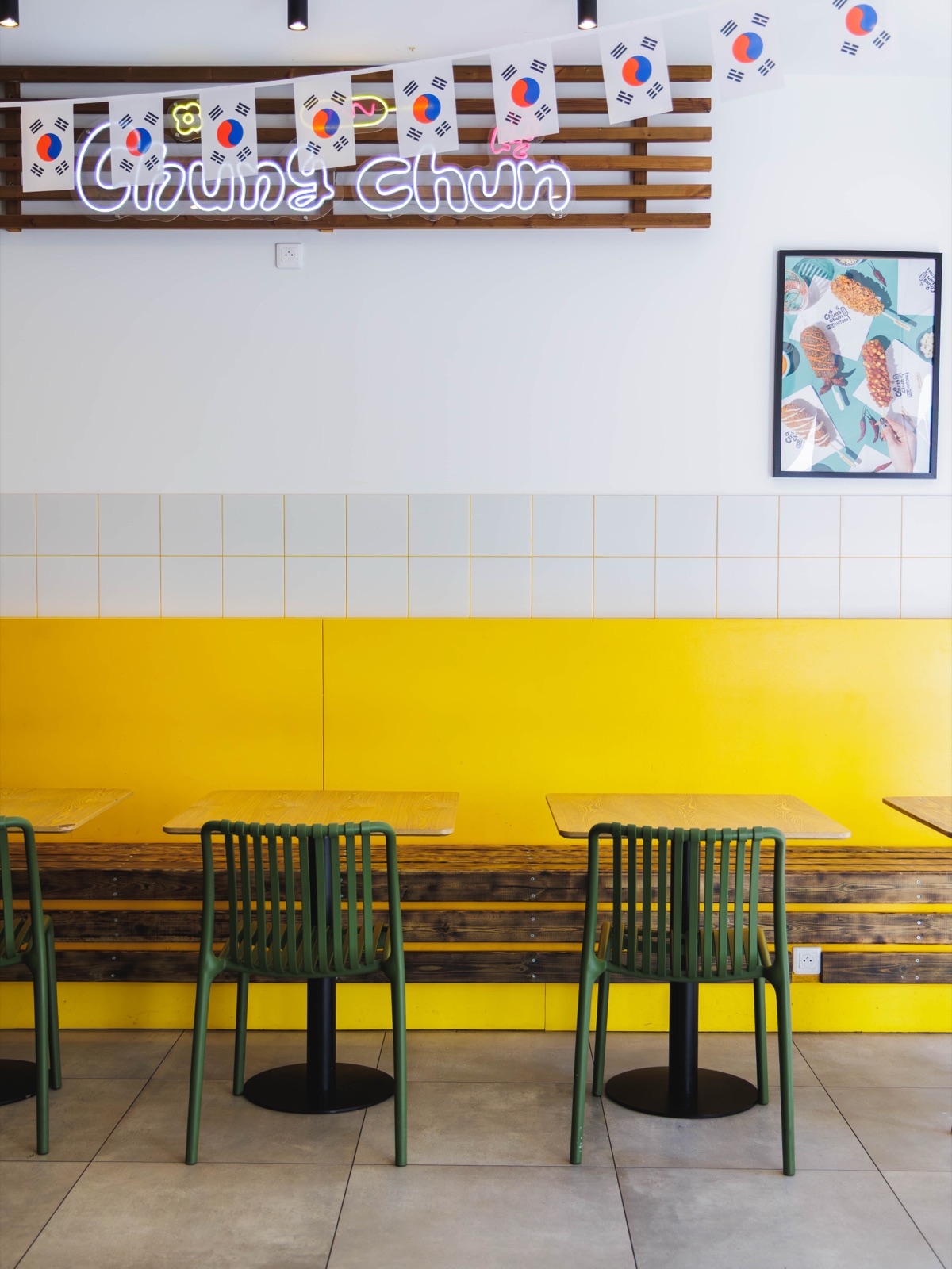 Salle du restaurant Chungchun à Nice : mur jaune, enseigne, drapeaux coréens et chaises vertes