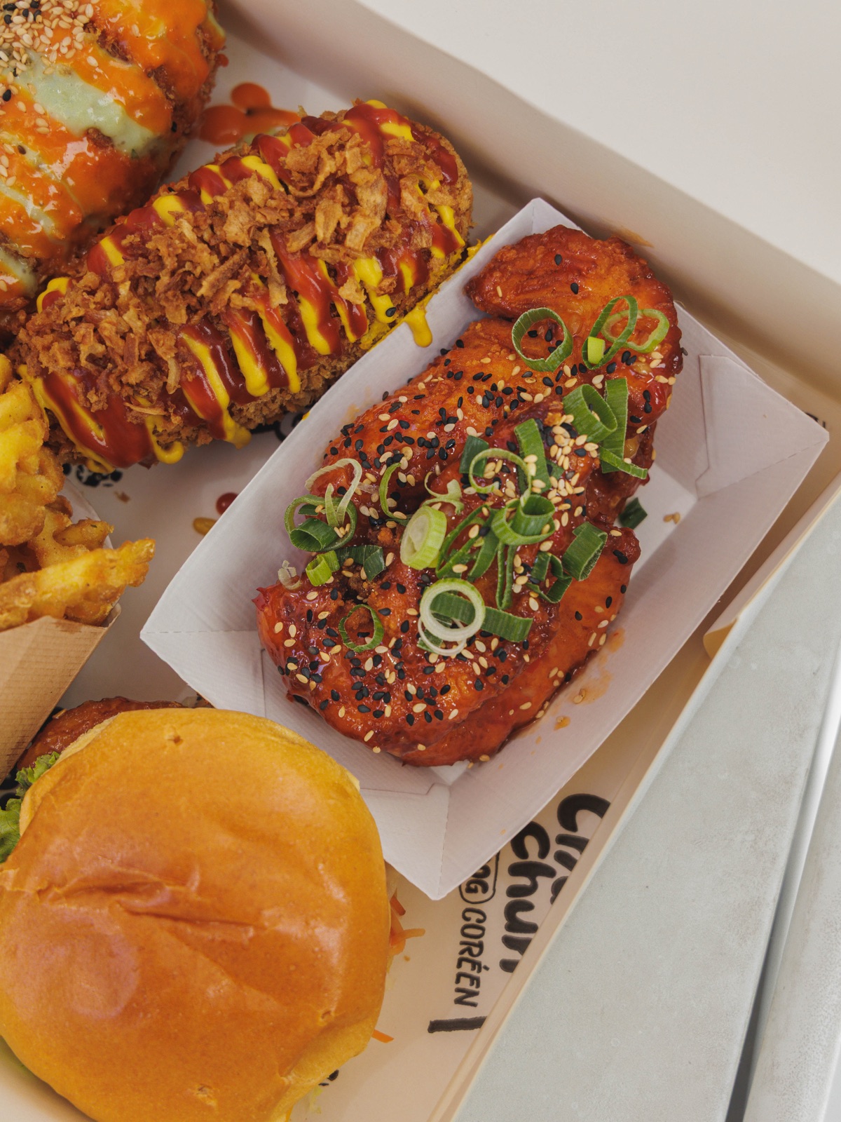 Plateau Chungchun généreux : Rice Dogs, poulet croustillant coréen, burger et waffle fries en barquette