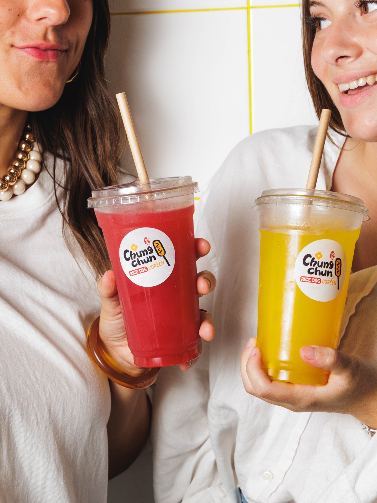 Deux clientes trinquant avec des gobelets Chungchun : Seoul Ade fraise et mangue