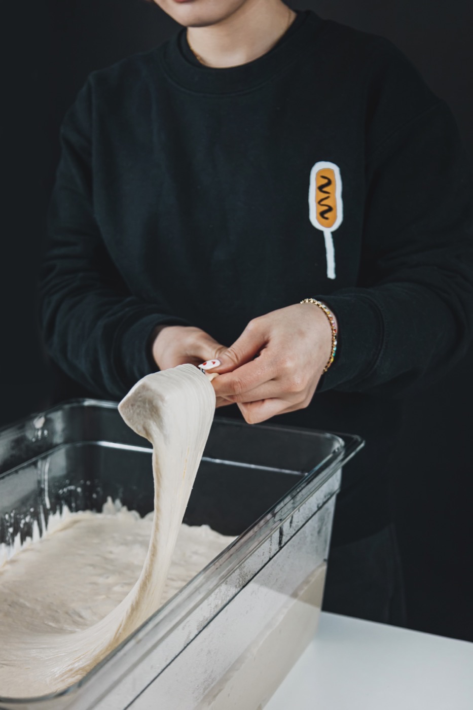 Pâte gluante à la farine de riz étirée à la main au-dessus de son bac, préparée fraîche chez Chungchun
